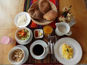 una mesa con platos de comida, café y pan en Ayllu B&B Ollantaytambo, en Ollantaytambo