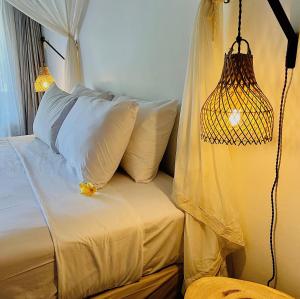 Pearl Boutique Hotel Adult only في ليغِيان: غرفة نوم بسرير مع مظلة ومصباح