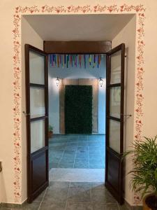 un corridoio con una porta aperta e bandiere appese al muro di Mesón del Alcalde a Lagos de Moreno