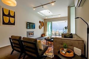 a living room with a couch and chairs at Travellers Haven Queenstown Hill in Queenstown