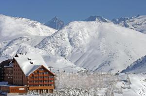 a ski lodge in front of a snow covered mountain at Le Pic Blanc in L'Alpe-d'Huez