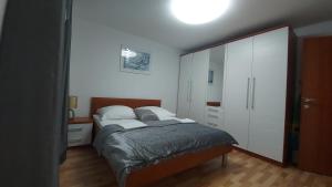 a bedroom with two beds and a large white cabinet at Apartments Ana Kroatien Vodice in Vodice