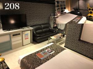 sala de estar con sofá de cuero negro y TV en ホテルレスポアール, en Minatomachi