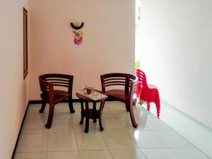 une chambre avec des chaises, une table et une horloge sur le mur dans l'établissement RedDoorz @ Makarios Hotel Poso, à Poso