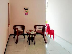 a room with chairs and a table and a clock on the wall at RedDoorz @ Makarios Hotel Poso in Poso