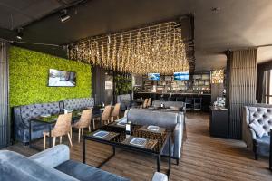 a restaurant with couches and a table and chairs at Altyn Eco Park in Astana