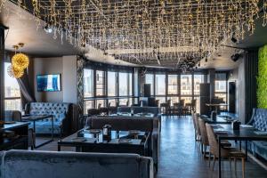 a restaurant with tables and chairs and a chandelier at Altyn Eco Park in Astana