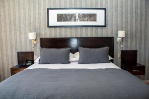 a bedroom with a large bed with two lamps and a picture on the wall at Hotel RP in Temuco