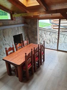 a dining room with a wooden table and a stone fireplace at Chata Aneta in Námestovo