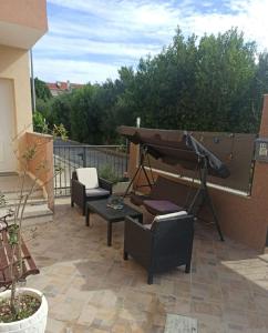 een patio met stoelen en een piano op een balkon bij Apartments Matko-200m from the beach in Kaštela