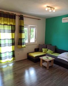 een woonkamer met een bank en een tafel bij Apartments Matko-200m from the beach in Kaštela