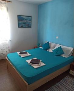 een slaapkamer met een blauw bed en handdoeken bij Apartments Matko-200m from the beach in Kaštela