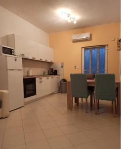 een keuken met een tafel en stoelen en een koelkast bij Apartments Matko-200m from the beach in Kaštela