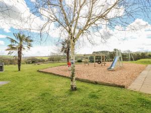 ein Park mit einem Spielplatz mit Rutsche in der Unterkunft Grooms Cottage in Tenby