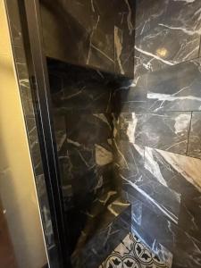 a shower in a bathroom with a stone wall at The Kanab Lodge in Kanab