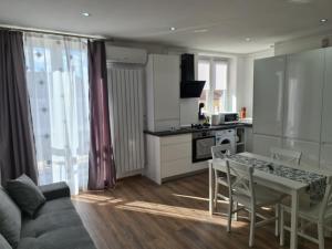 a kitchen and living room with a table and a couch at The Best Apartment in Hunedoara +11 photos