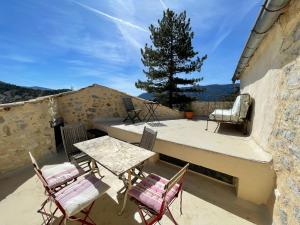 d'une terrasse avec une table, des chaises et un arbre. dans l'établissement La Maison de Vergol, à Montbrun-les-Bains