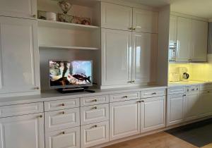 una cocina con armarios blancos y TV en una encimera en Haus Friedeburg Gödeke, en Rantum