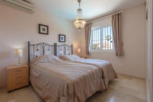 sypialnia z łóżkiem, oknem i żyrandolem w obiekcie Super Villa priv heated pool 3bed w mieście La Cala de Mijas +24 zdjęcia