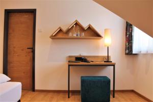 a room with a desk with a lamp and a door at Gasthaus Steidl in Bauerbach