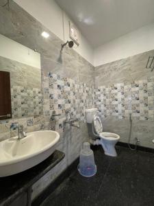 a bathroom with a sink and a toilet at Hotel Royal Embassy in Tinsukia