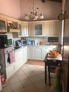 a kitchen with white cabinets and a bowl of oranges on a table at Villa cassandra in Maratea