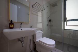 a white bathroom with a sink and a toilet at Greystone Continew Residensi in Kuala Lumpur