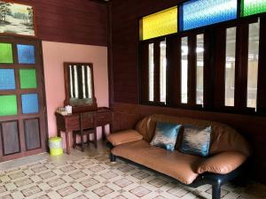 a leather couch in a room with stained glass windows at Pop riverside trat in Trat