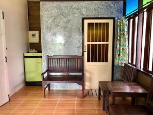 a kitchen with two wooden benches and a door at Pop riverside trat in Trat