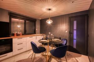 a kitchen with purple chairs and a table in a kitchen at Villa avec jacuzzi privatif in Saint-Cyr-lʼÉcole