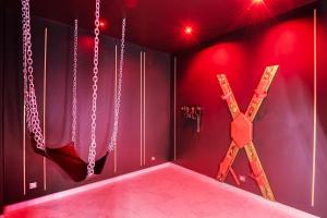 a room with chains hanging on the wall and a room with a room at Villa avec jacuzzi privatif in Saint-Cyr-lʼÉcole