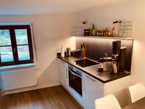 a kitchen with a stove and a sink and a window at FELIX LIVING 2, Cozy & modern & Netflix Wohnung mit Blick ins Grüne in Passau