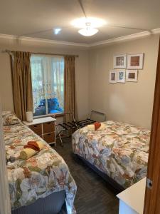 a hotel room with two beds and a window at Cozy Cottage Victor Harbor in Hindmarsh Valley