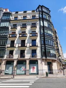 um edifício alto com janelas numa rua da cidade em Habitaciones Turísticas Bilbao Centro con aire acondicionado em Bilbau