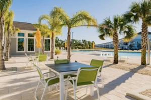 a patio with a table and chairs next to a pool at Azure Dream in Perdido Key