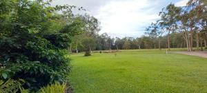 um grande campo verde com árvores ao fundo em Tukawyl Retreat Landsborough em Landsborough