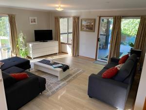 uma sala de estar com dois sofás e uma televisão em Cozy Cottage Victor Harbor em Hindmarsh Valley