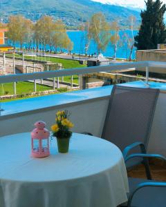une table blanche avec un pot de fleurs sur un balcon dans l'établissement Exclusive Apartments with Lake view, à Ohrid