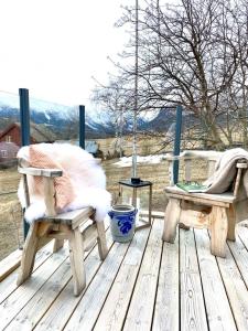 two wooden chairs sitting on a wooden deck at Stort og autentisk hus i Skjåk - kort vei til Lom! in Skjåk