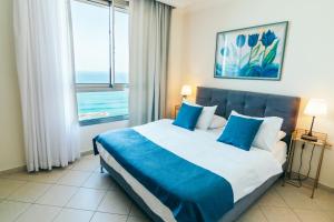 Tempat tidur dalam kamar di Almog Beach apt Hotel מלון דירות אלמוג ביץ'