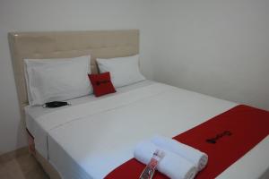 A bed or beds in a room at RedDoorz near Mall Ratu Indah 3