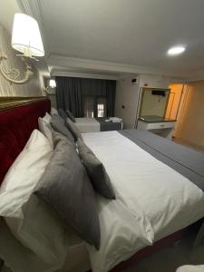 um quarto com uma grande cama branca com almofadas em RHYTHM HOTEL em Istambul