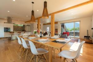 a dining room with a large wooden table and white chairs at Yuzuki in Kutchan