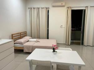 1 dormitorio con 1 cama, mesa y sillas en D13A, CYBERJAYA, Netflix, Wifi, Free Parking, Balcony, 2013, en Cyberjaya