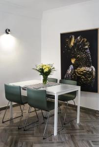 uma mesa de jantar com cadeiras e um vaso de flores em Appartement charmant et calme aux portes de Monaco em Cap d'Ail