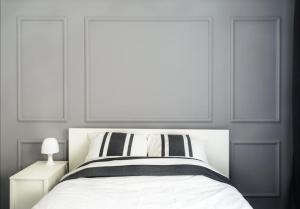 a white bed with black and white pillows at Appartement charmant et calme aux portes de Monaco in Cap d'Ail