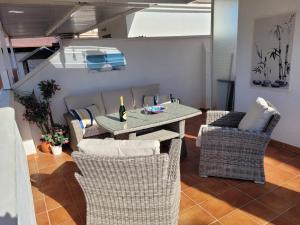 stół i krzesła z butelką wina w obiekcie Penthouse Clavero Casasol w mieście Nerja