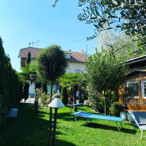 a yard with a table and a bench in the grass at Garni San Paolo in Appiano sulla Strada del Vino