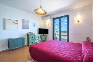 um quarto com uma grande cama rosa e uma janela em La terrazza sul Mare em Agnone Bagni