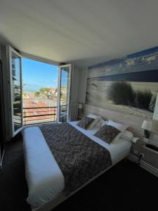 a bedroom with two beds and a large window at Chez-Marion in Merville-Franceville-Plage